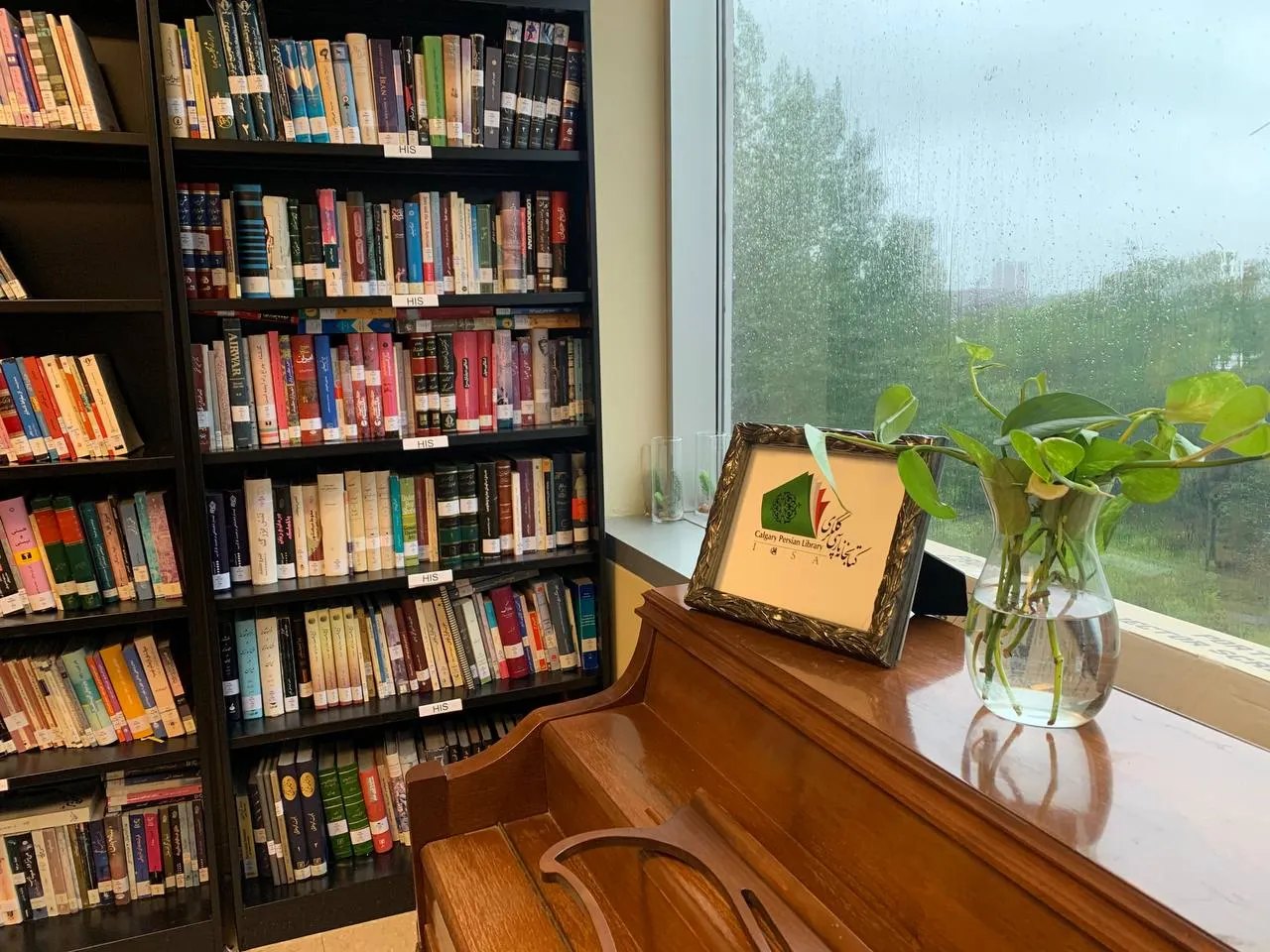 Bookshelves and piano inside Calgary Persian Library